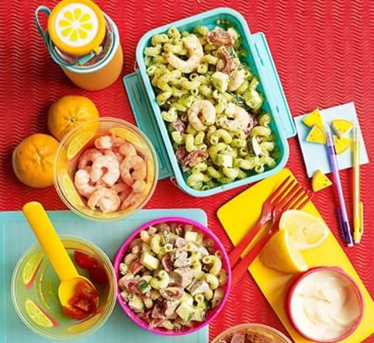A table topped with bowls of food next to oranges