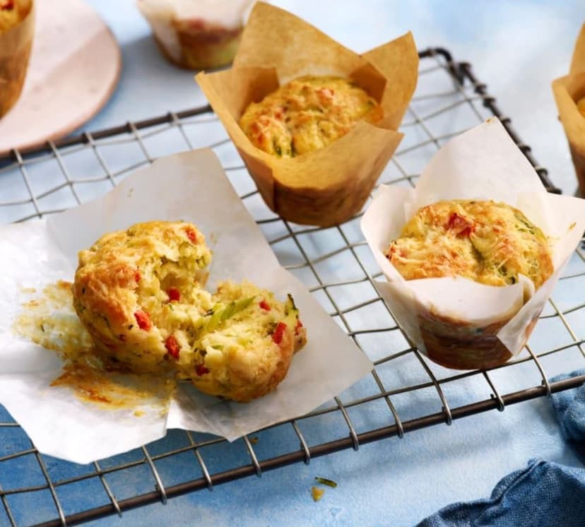 Several muffins on a cooling rack on a table