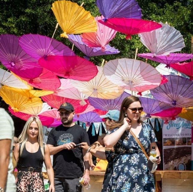 A group of people walking down a street under umbrellas
