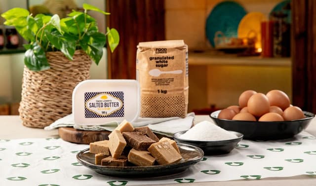 A table topped with bowls of food and a bag of eggs